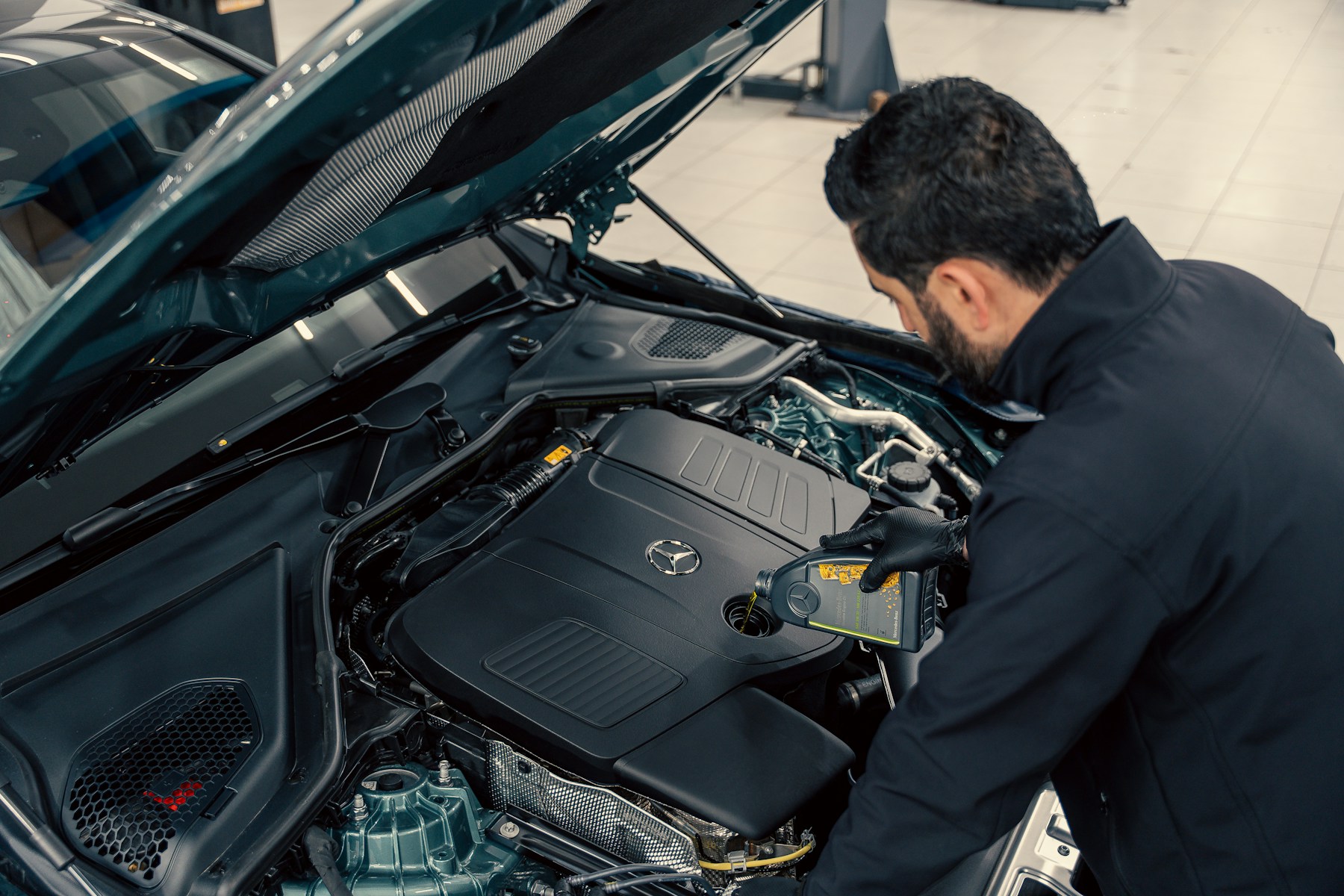 Automotive specialist working underneath a vehicle in a modern workshop